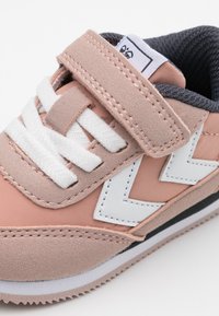 Rosa Wildleder- und Synthetik-Sneaker mit weißen Akzenten, Klettverschluss, runden Schnürsenkeln und strukturiertem Sohle mit Zickzackmuster.