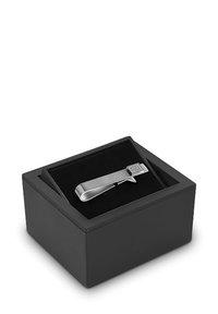 Srebrny metalowy klips do krawata o geometrycznym wzorze, zaprezentowany w czarnym prostokątnym pudełku z miękkim czarnym wnętrzem.