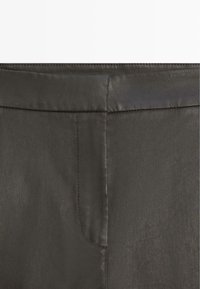 Close-up of dark gray pants waistband and fly area with visible stitching and smooth fabric texture.