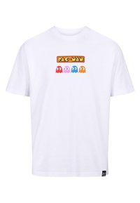 Camiseta de algodón blanca con un logo impreso de "PAC-MAN" y cuatro personajes fantasma de colores (rojo, rosa, azul, naranja) en la parte frontal.