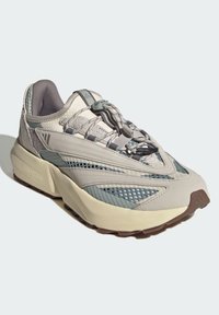 Ľahké tenisky v sivej a béžovej farbe, s plošinami z oka, textúrovanými detailmi, gumovou podrážkou a bungee šnúrkami pre bezpečné upevnenie.