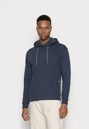 Sudadera con capucha de color navy, de manga larga, con un bolsillo tipo canguro y cordones con un patrón en contraste. Presenta un pequeño logo en el pecho.