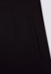 Pantaloni neri su misura con una texture liscia, tasche laterali a fessura e linee pulite senza cuciture visibili o decorazioni.