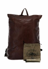 Zaino in pelle marrone con parte superiore arrotolata, tasca frontale e manico. Include una borsa in tela e un tubetto di prodotto per la cura della pelle.