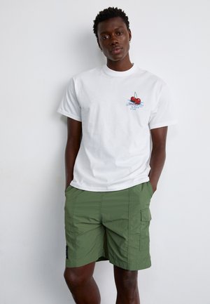 Biała bawełniana koszulka z grafiką wiśni na piersi, zestawiona z oliwkowymi szortami cargo z bocznymi kieszeniami i luźnym krojem.