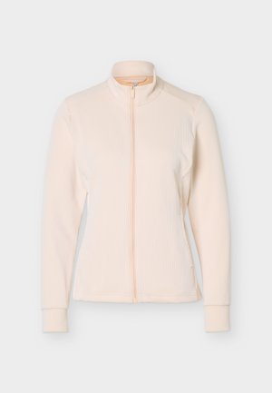 Veste beige clair côtelée à manches longues avec fermeture éclair intégrale à l'avant et col montant, présentée sur un fond neutre.