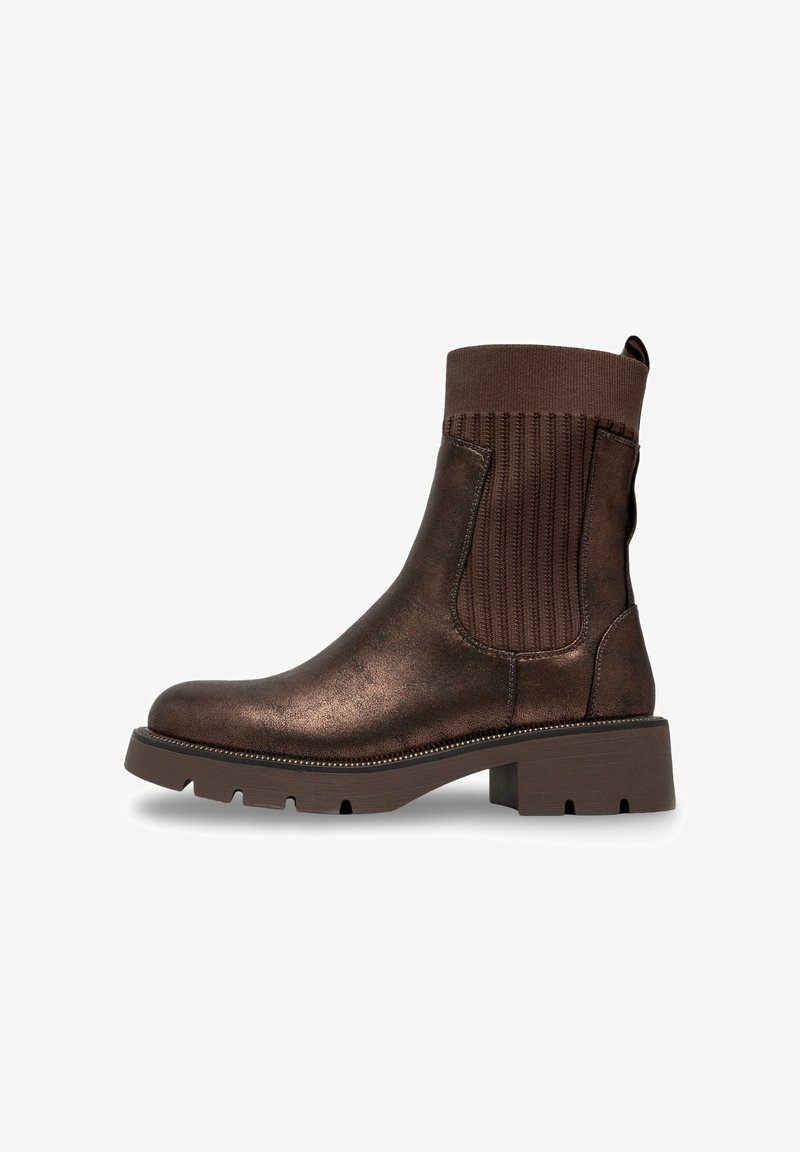 Bottines en cuir marron avec des panneaux élastiques côtelés sur les côtés, semelle épaisse et bout rond. Présente une subtile brillance et une languette à l'arrière.