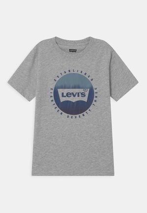 Jasnoszary t-shirt Levi's z krótkim rękawem, z niebieskim okrągłym logo i napisem „Established Eighteen Seventy Three” wokół niego.