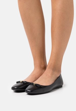 Sorte læder balletflade med en rund tå, der har en lille sløjfe detalje og en gylden accent foran. Flad således design.