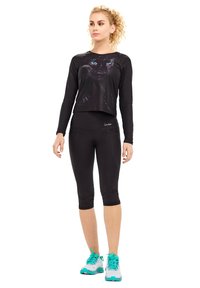 Black long-sleeve crop top featuring a graphic of a cat's face, paired with black capri leggings and teal-accented athletic shoes.