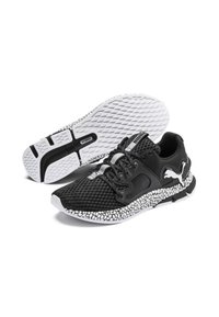 Baskets de sport noires avec une tige en maille texturée, semelle blanche émaillée, et logo bien en vue. Dispose de lacets et d'une semelle intérieure rembourrée.