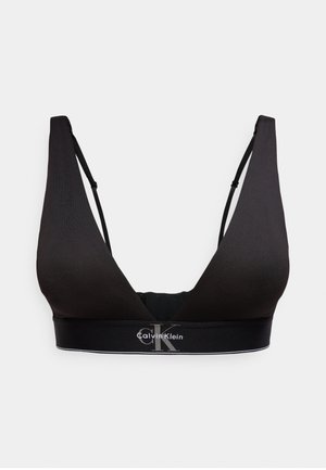 Bralette nero Calvin Klein con spalline regolabili e fascia elastica con marchio sotto il busto su sfondo chiaro.
