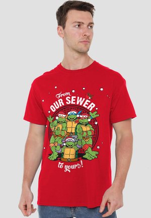 Red cotton t-shirt featuring animated turtles, festive hats, and the text "From our sewer to yours!" in a playful design.