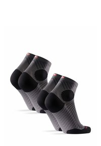 Calcetines cortos en negro y gris con un diseño texturizado, talón y puntera reforzados, con un logo rojo y un acolchado circular en la zona del talón.