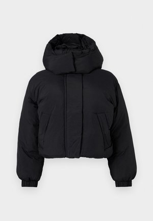 Melna īsā pūkainā jaka ar augstu piepūsto apkakli, garām piedurknēm ar elastīgām aprocēm un divām priekšējām kabatām.