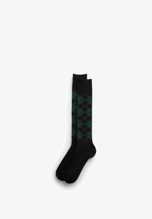 Paar schwarze knielange Socken mit grünem und dunkelgrauem Rautenmuster im Beinbereich.