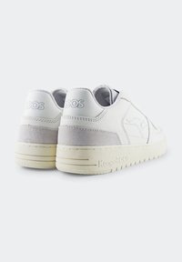 Białe skórzane sneakersy z szarymi zamszowymi akcentami, wyściełanym kołnierzem i teksturowaną gumową podeszwą. Posiadają wytłoczone logo na pięcie i minimalne przeszycia.