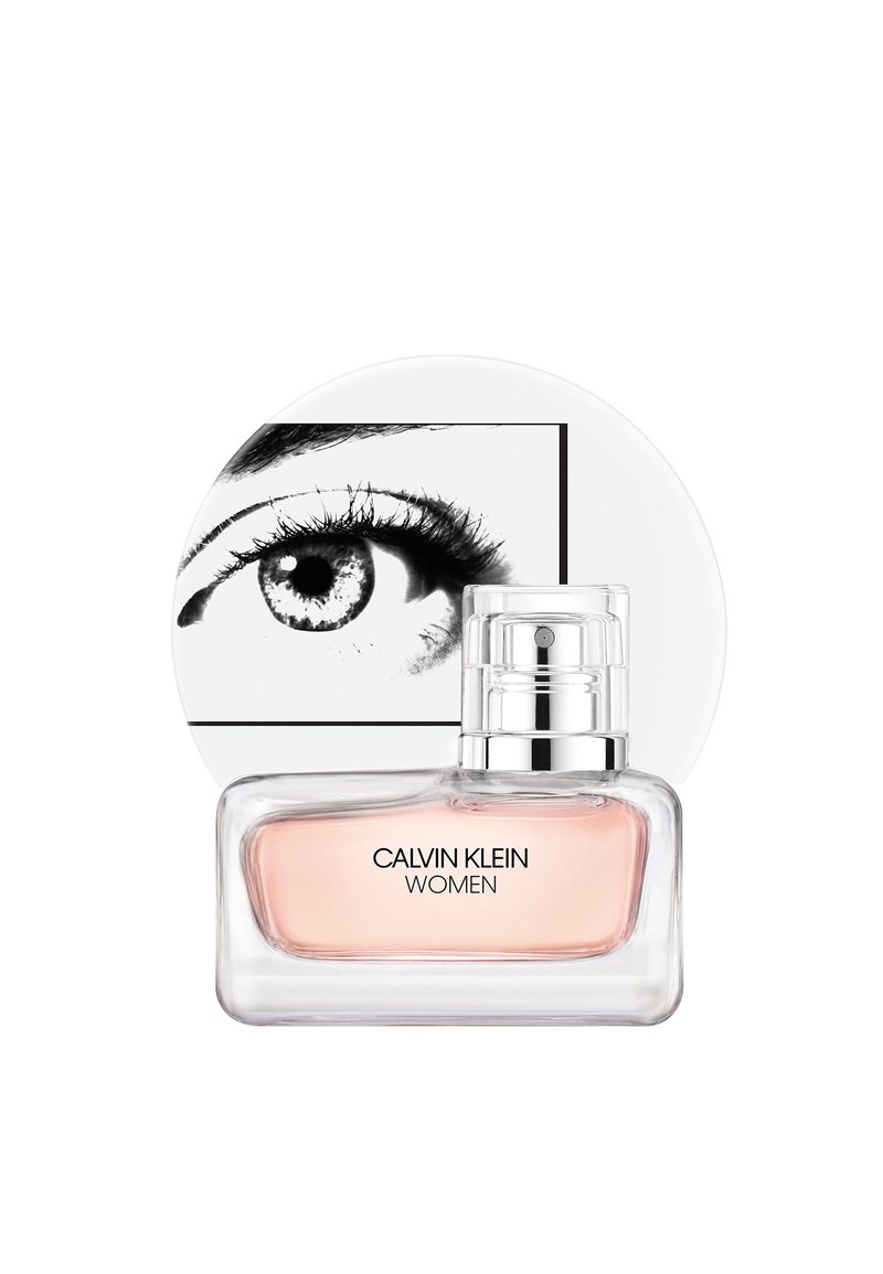 Calvin Klein Women parfym i en klar rektangulär flaska, rosa vätska, silverlock, med en cirkulär vit förpackning med en svart ögonillustration.