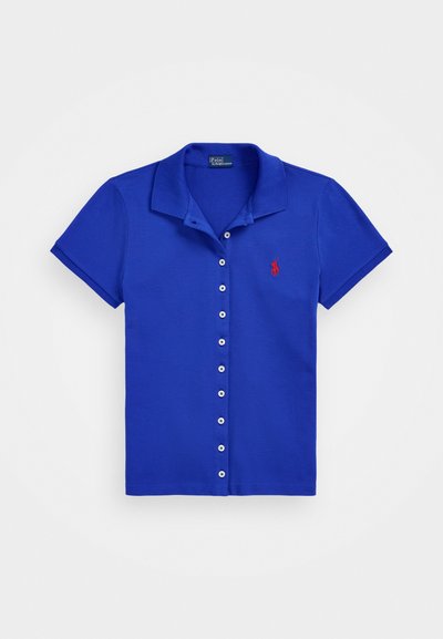 Blå polo skjorte med krage, korte ermer, knappelukking foran og rød brodert logo på venstre bryst. Jevn stofftekstur.