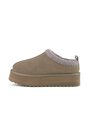 Chaussure en daim marron à enfiler, avec un col en fourrure grise épaisse, une semelle plateforme épaisse et des coutures le long du bord supérieur. Surface texturée.