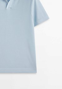 Polo bleu clair à manches courtes avec col et ourlet côtelé présenté sur fond blanc.