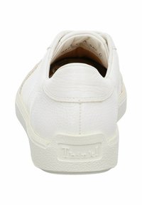 White leather sneaker with a textured finish, rounded heel, and a rubber sole. Features subtle brand logo on the back.