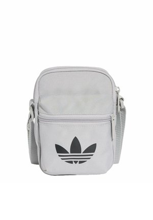 Malá světle šedá látková crossbody taška s předním kapsou na zip a černým logem Adidas trefoil na přední straně.
