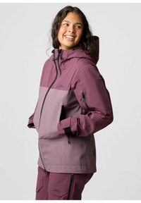 Veste imperméable avec un design bicolore dans des teintes de mauve, dotée d'une capuche, de poches zippées et de poignets ajustables. Texture de tissu durable.