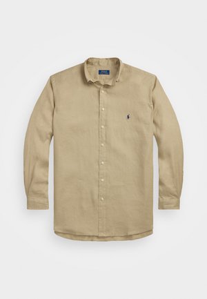 Chemise beige à manches longues avec boutons en lin, dotée d'un col classique, d'une texture subtile et d'un petit logo bleu marine sur la poitrine gauche.