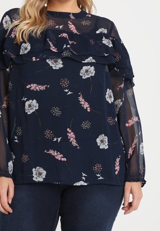 Marinebluse mit floralem Muster; verfügt über geschichtete Rüschen, lange transparente Ärmel und elastische Bündchen. Leichtes, fließendes Material.
