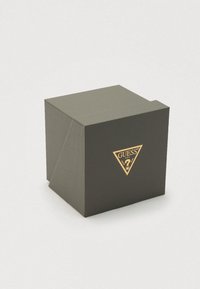 Dark gray box with a textured finish, featuring a gold triangular logo on the front, angled edges, and a folded lid design.