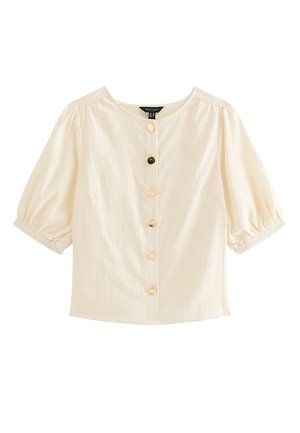 Blusa crema a maniche corte con scollatura rotonda, maniche a sbuffo e cinque bottoni decorativi diversi sul davanti.