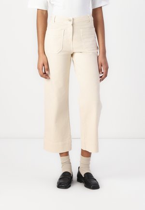 Wide-leg trousers in light beige cotton, featuring a high waist, front button closure, and two back pockets. Accented with a clean hem.