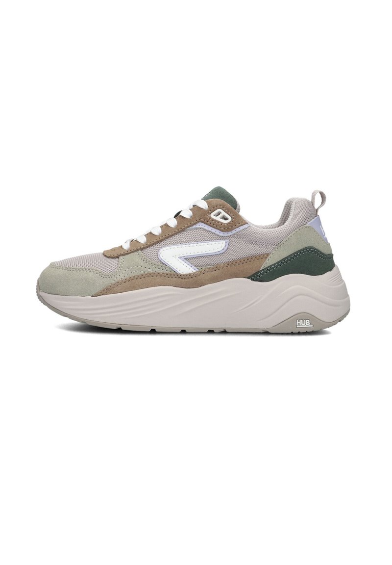 Schoen met een beige en groene kleurenpalet, een textuur-mesh bovenwerk, suede accenten en een dikke witte rubberen zool.