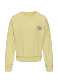 Un sweat-shirt jaune à col rond, avec des poignets et un ourlet côtelés, et un petit écusson aux accents multicolores sur le côté gauche de la poitrine.
