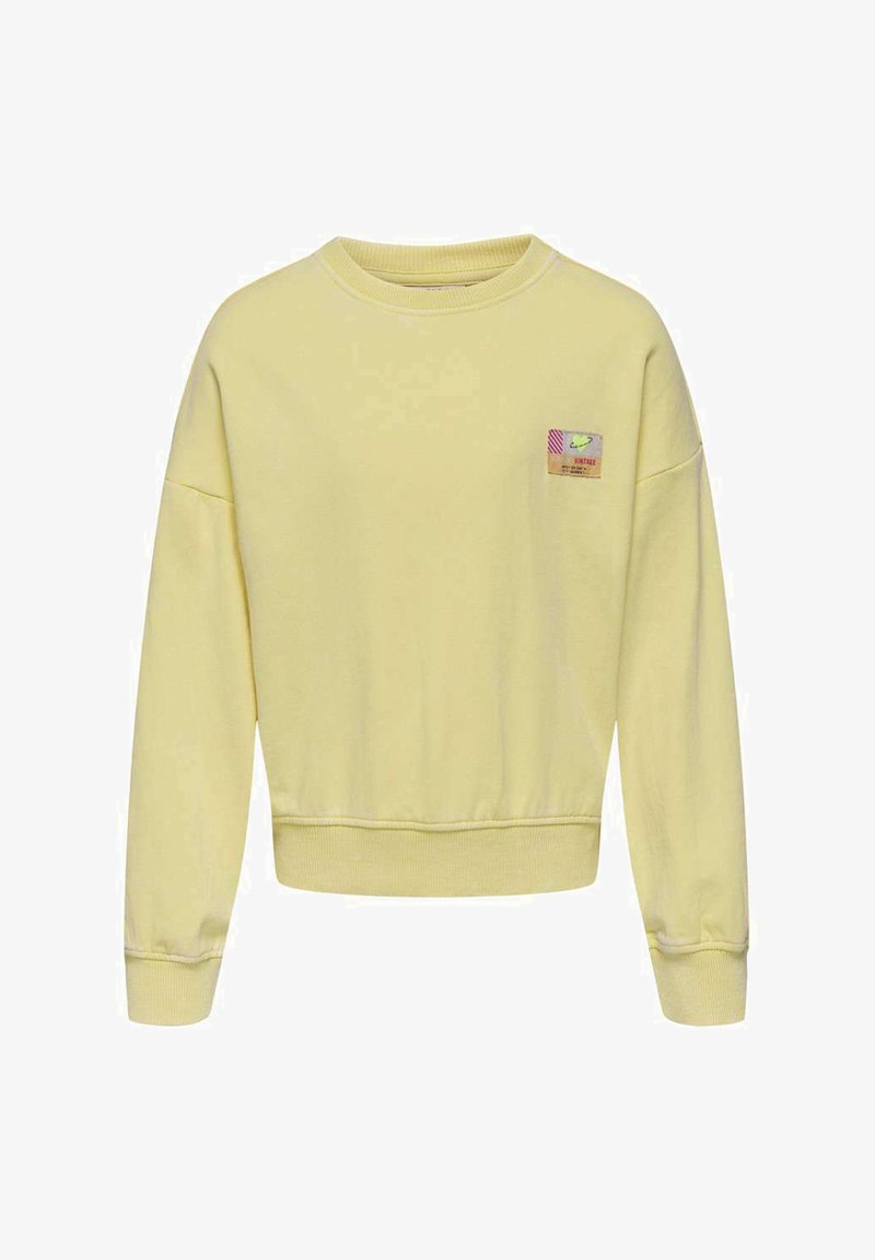 Un sweat-shirt jaune à col rond, avec des poignets et un ourlet côtelés, et un petit écusson aux accents multicolores sur le côté gauche de la poitrine.