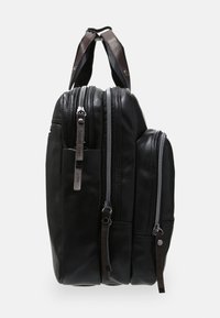 Černý kožený batoh s třemi zipovými přihrádkami, texturovaným povrchem a tmavě hnědými akcenty na horním madle.