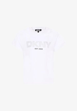 T-shirt blanc à manches courtes avec "DKNY" en lettres pointillées et "EST. 1989" imprimé en dessous sur le devant, étiquette noire visible au niveau du col.