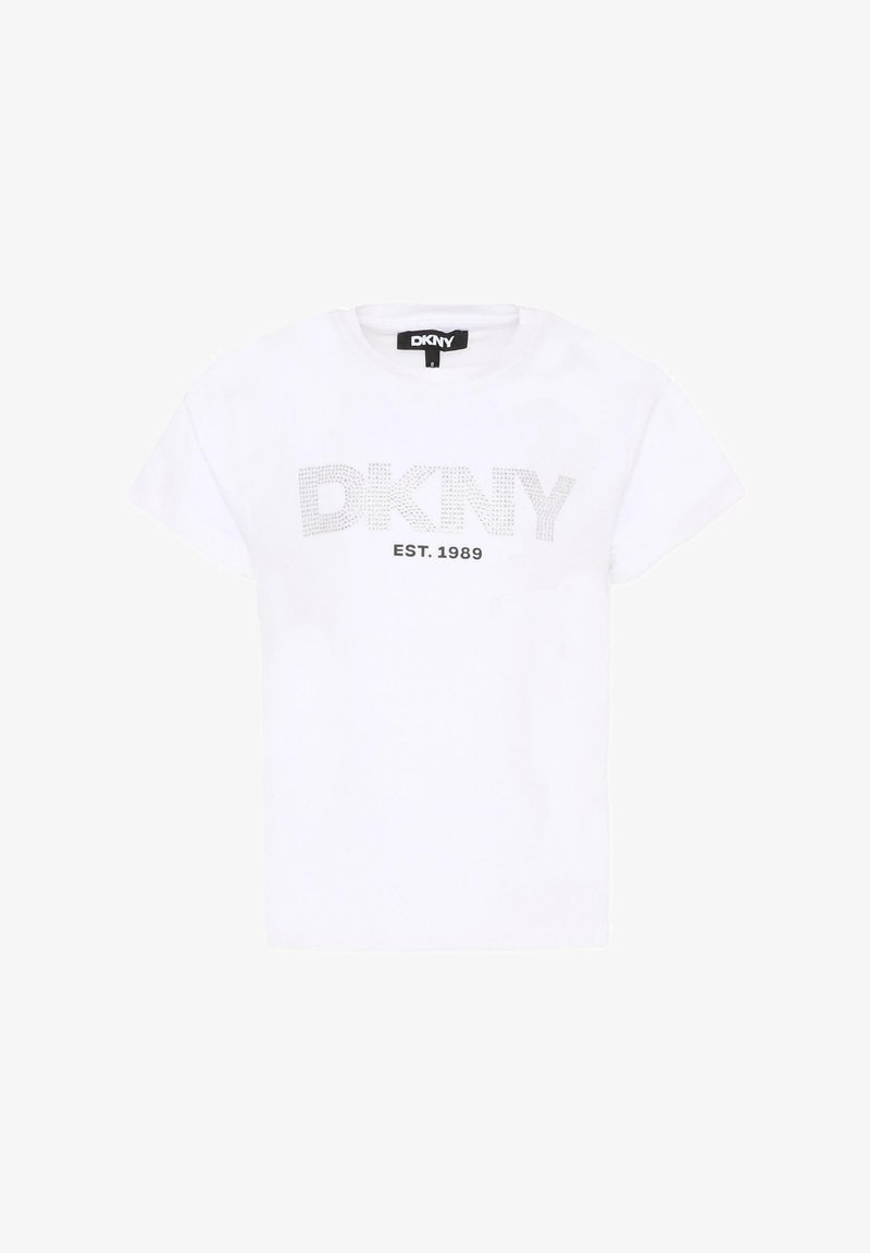 T-shirt blanc à manches courtes avec "DKNY" en lettres pointillées et "EST. 1989" imprimé en dessous sur le devant, étiquette noire visible au niveau du col.