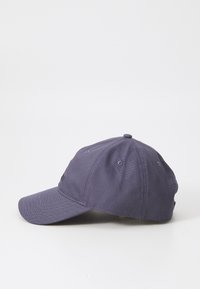 Purple cotton baseball cap with a rounded crown, curved brim, and logo detail on the side. Features ventilation holes for breathability.
