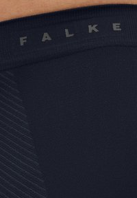 Schwarzer Strickstoff mit einem gerippten Bund, der die Marke "FALKE" in Grau geprägt zeigt. Die Textur wirkt glatt mit dezenten Streifen.