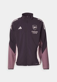Lila Adidas-Jacke mit hohem Kragen, vollständigem Reißverschluss, weißen Akzenten und Arsenal-Logo. Sie besteht aus leichtem Material und hat kontrastierende Seitenpaneele.