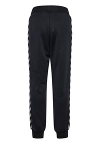 Pantalons de sport noirs avec des rayures latérales dans un motif contrasté, jambes fuselées, taille élastique et poignets côtelés. Texture de tissu lisse.