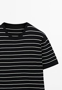 Sort og hvid stribet kortærmet t-shirt med rund halsudskæring. Stoffet ser blødt ud med en glat tekstur. Striberne er jævnt fordelt.