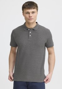 Gray polo shirt made of textured fabric, featuring a collared neck, three-button placket, and a small embroidered logo on the chest.