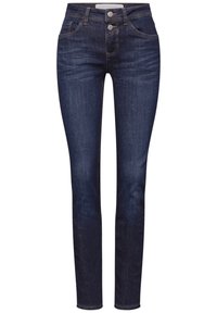 Jean skinny taille haute bleu foncé avec poches avant et arrière, fermeture à double bouton métallique et détails légèrement décolorés sur les cuisses.