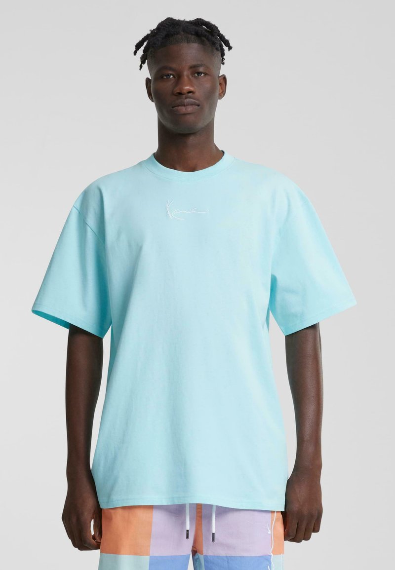 Light blue oversized t-shirt made of cotton, featuring a crew neck and short sleeves. Includes subtle white embroidered detailing on front.