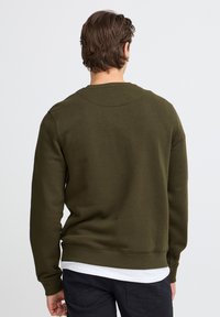 Donkergroene sweatshirt van katoen met een ronde hals, geribbelde mouwen en zoom, effen textuur en een ontspannen pasvorm. Achteraanzicht wordt getoond.