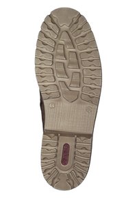 Suela de zapato diseñada para tracción, con una suela de goma texturada en color beige, con una sección central roja y elementos de agarre con un patrón.