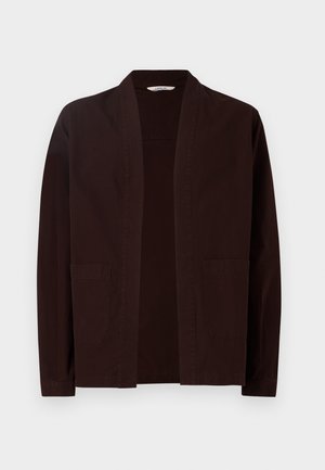 Jachetă maro închis, cu o croială lejeră, design cu fața deschisă, mâneci lungi și două buzunare frontale aplicate. Fabricată dintr-un material din bumbac ușor.